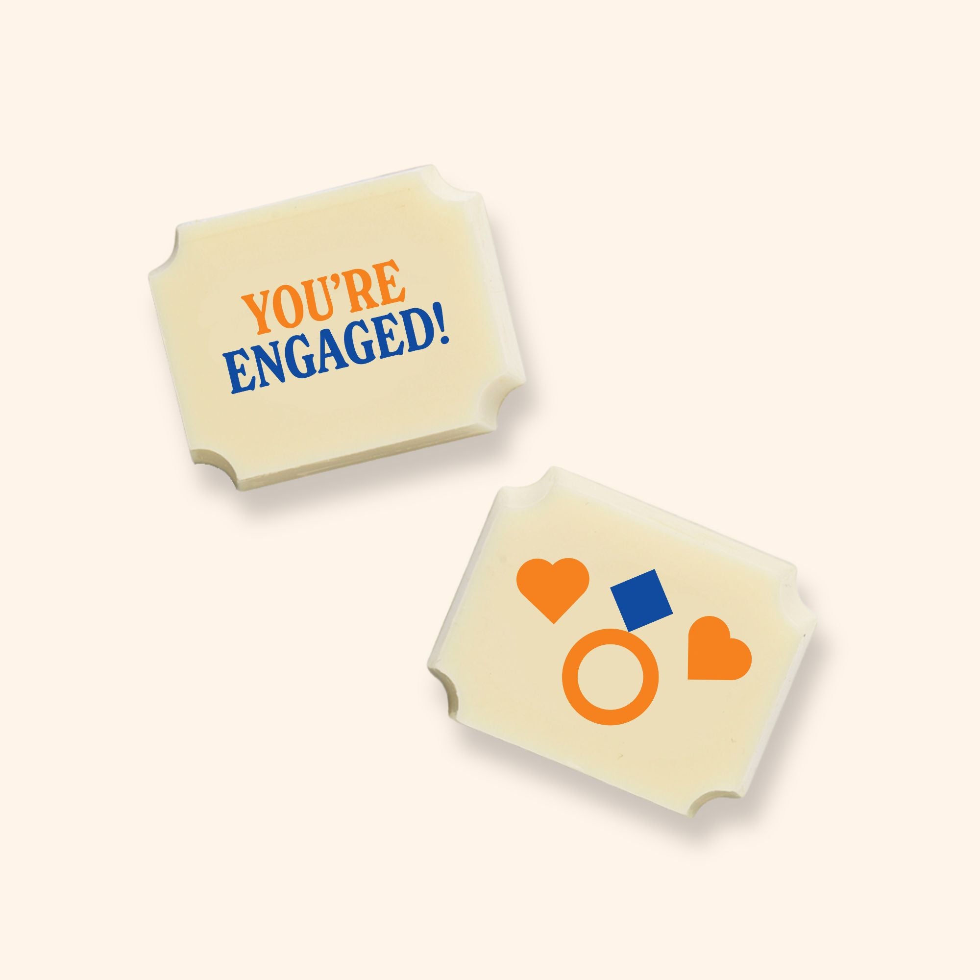 Two luxury white chocolates with a You're Engaged message