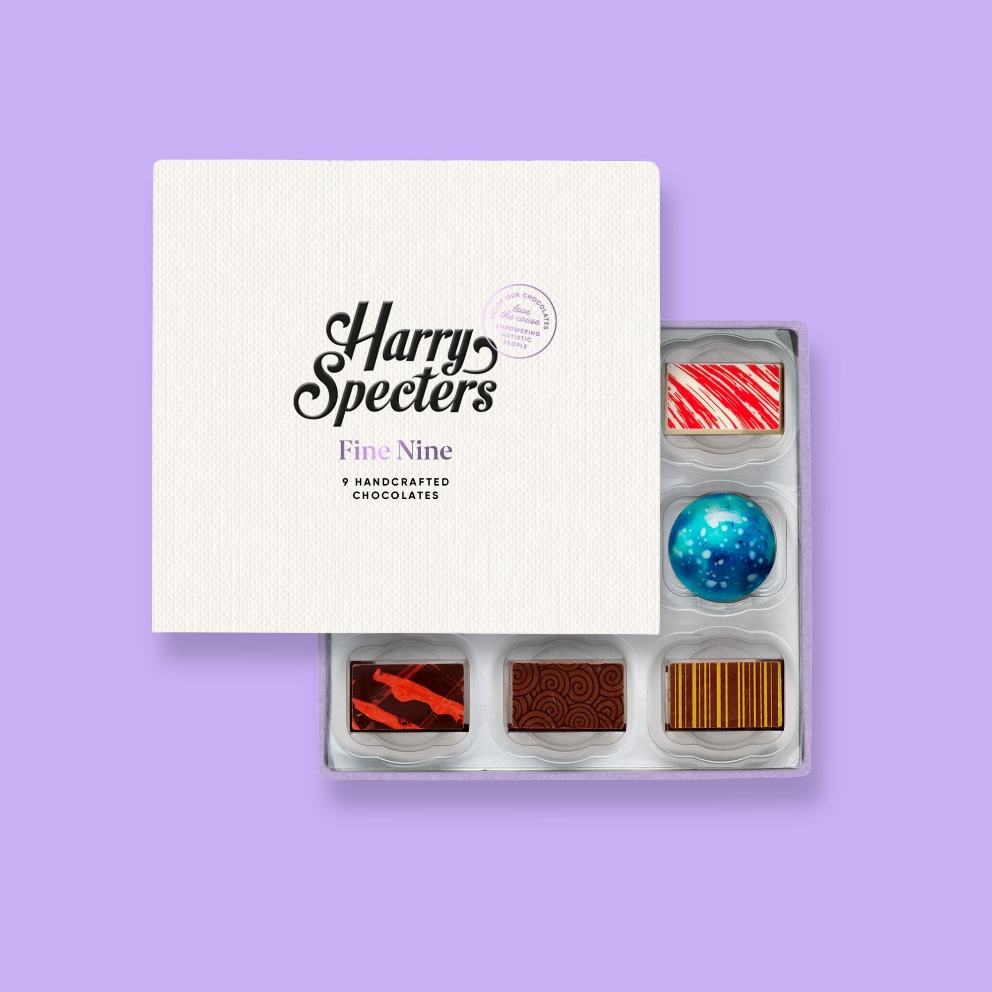A Harry Specters subscription box of 9 colourfully decorated artisan chocolates partially covered by a lid