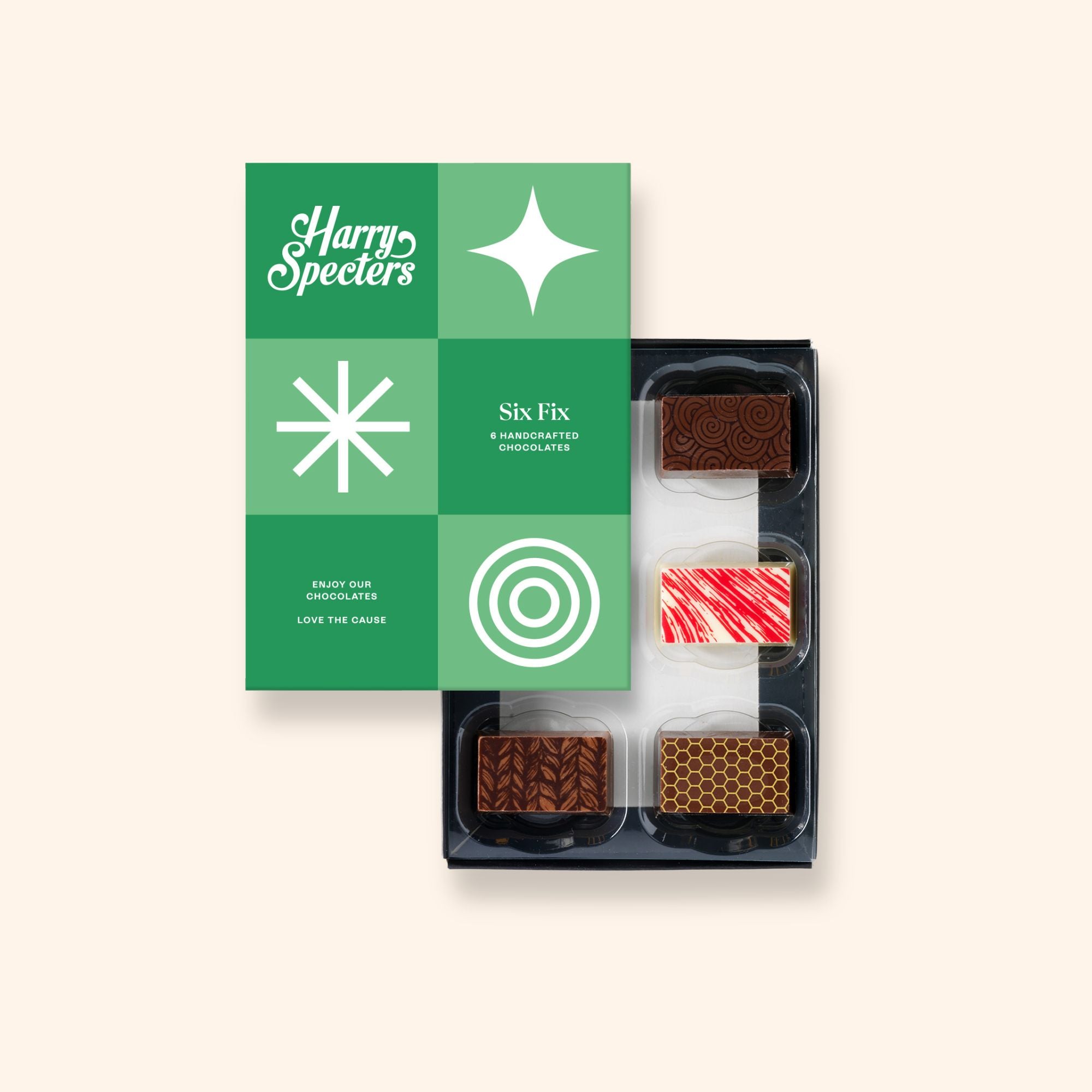 A box of 6 artisan chocolates partially covered by a box lid featuring the name Harry Specters
