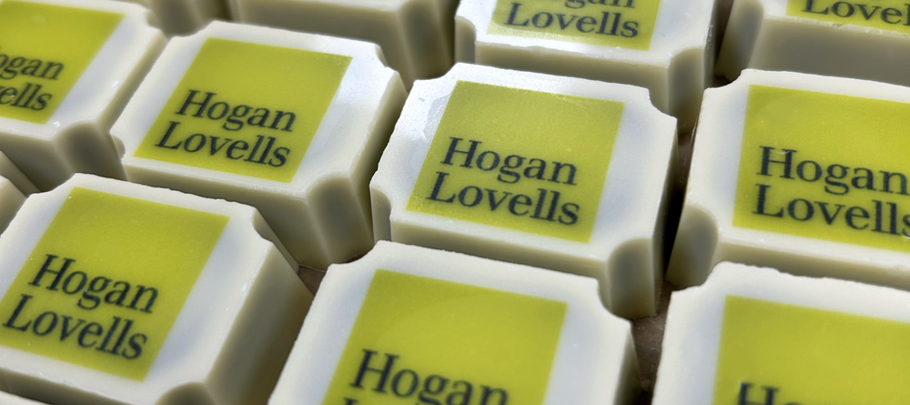White chocolates with a Hogan Lovells logo printed on them