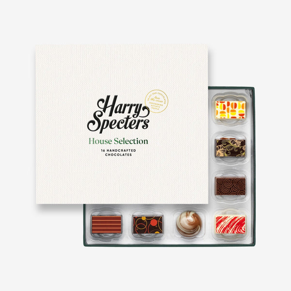 A box of 16 artisan chocolates by Harry Specters including Birthday themed designs partially covered by a box lid 