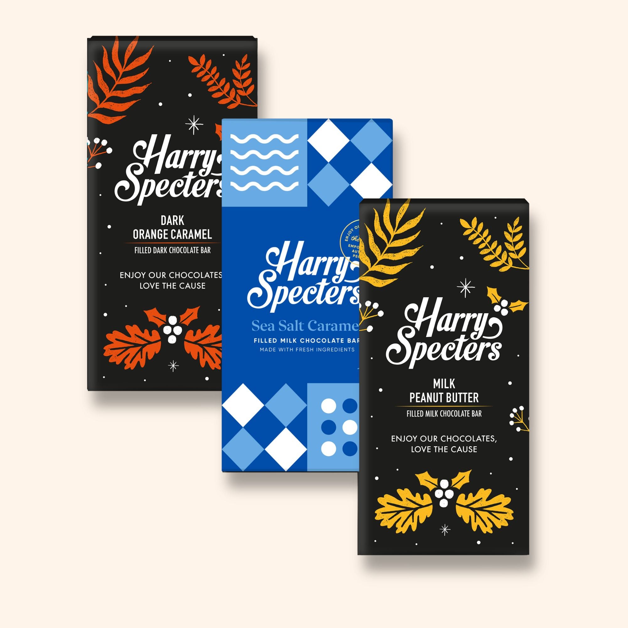 Three chocolate bars including dark vegan orange, sea salt caramel, and peanut butter flavours in festive Christmas packaging