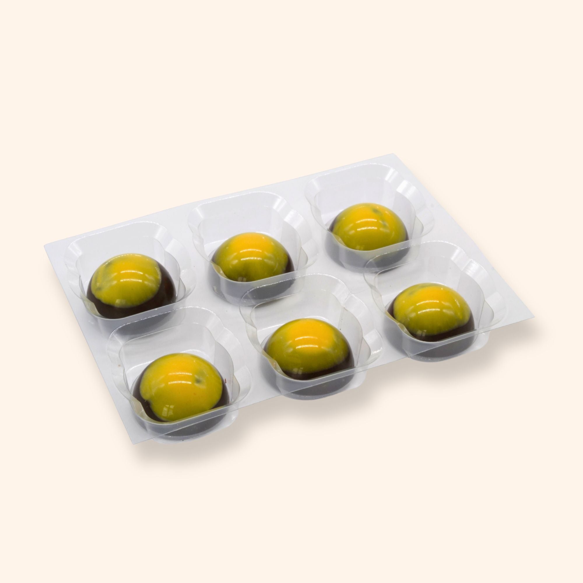 Pack of six mango calamansi chocolates in a clear plastic tray on a white background