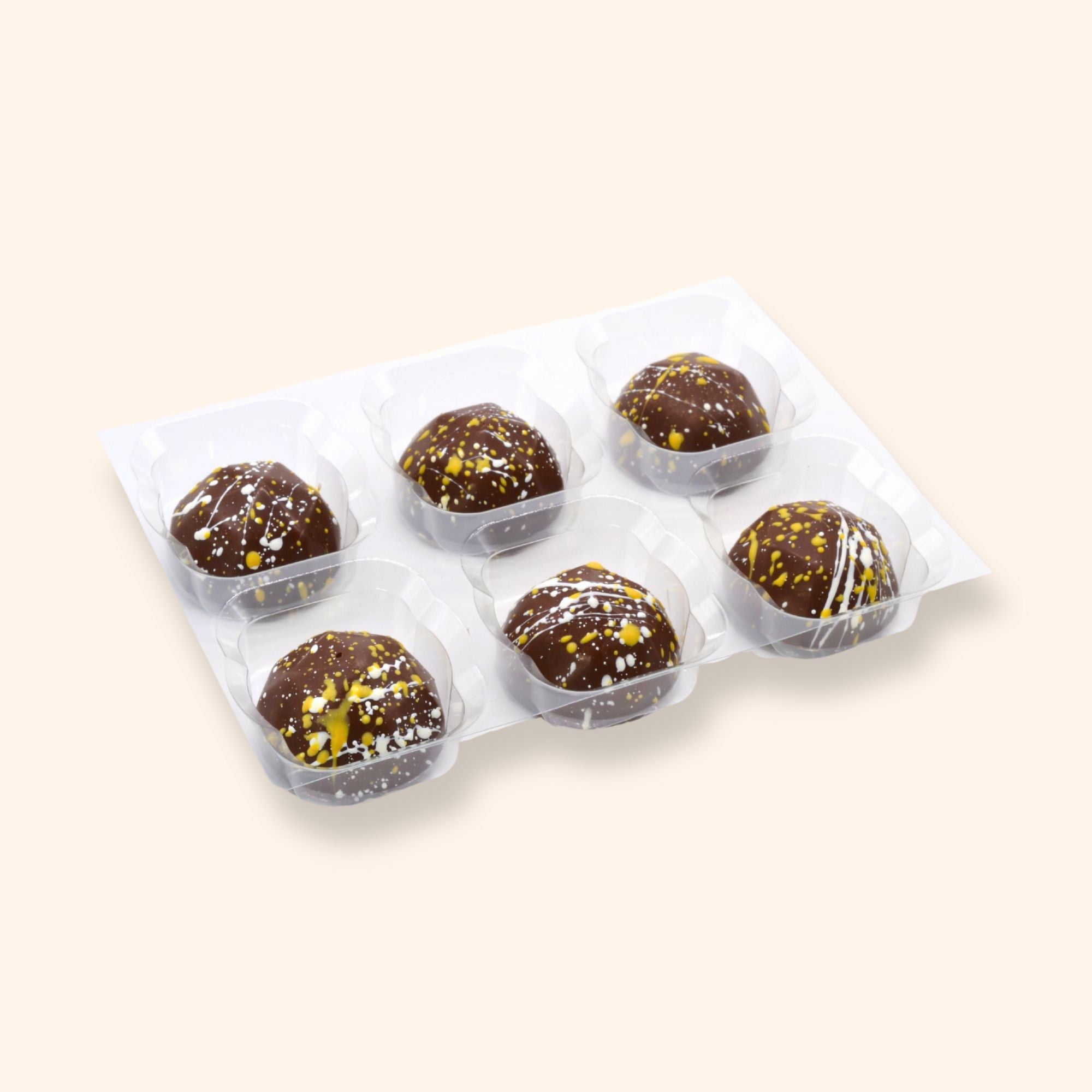 Pack of six pina colada chocolates in clear plastic packaging on a beige background