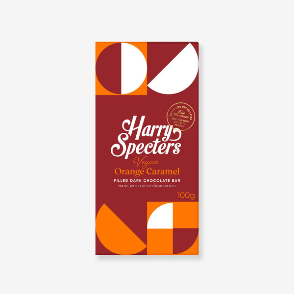 A dark vegan chocolate bar filled with orange caramel in colourful packaging showing the name Harry Specters