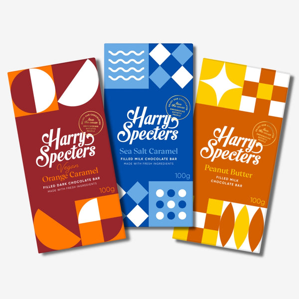 Three chocolate bars including dark vegan orange, sea salt caramel, and peanut butter flavours in colourful packaging