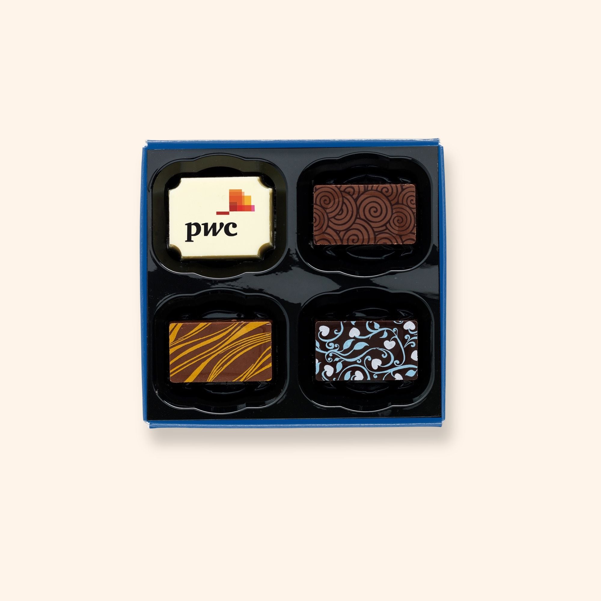 A box of 4 artisan chocolates colourfully decorated and featuring a personalised chocolate showing a company logo