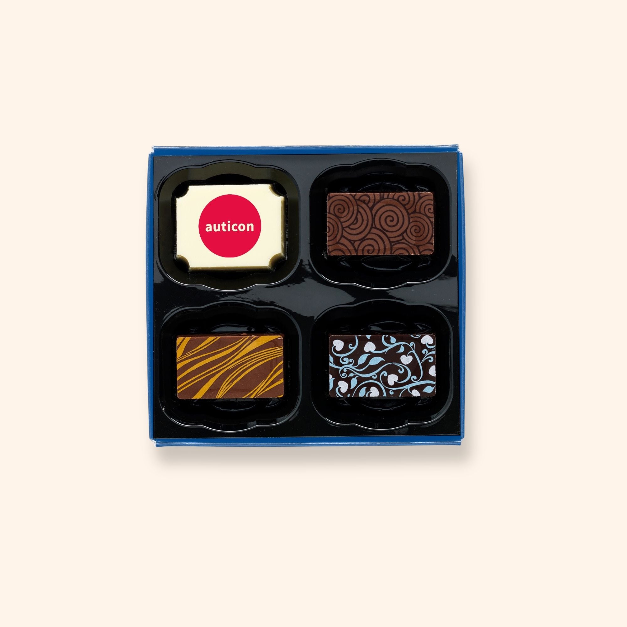 A box of 4 artisan chocolates colourfully decorated and featuring a personalised chocolate showing a company logo