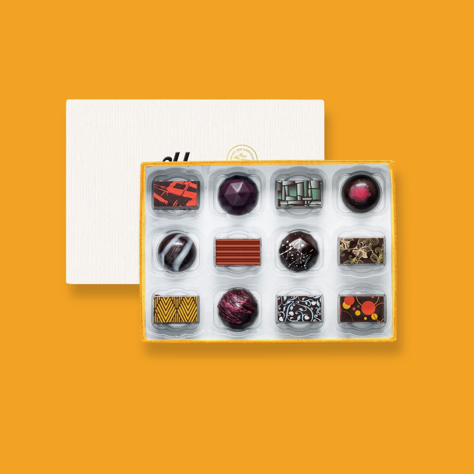 A box of 12 artisan vegan chocolates colourfully decorated
