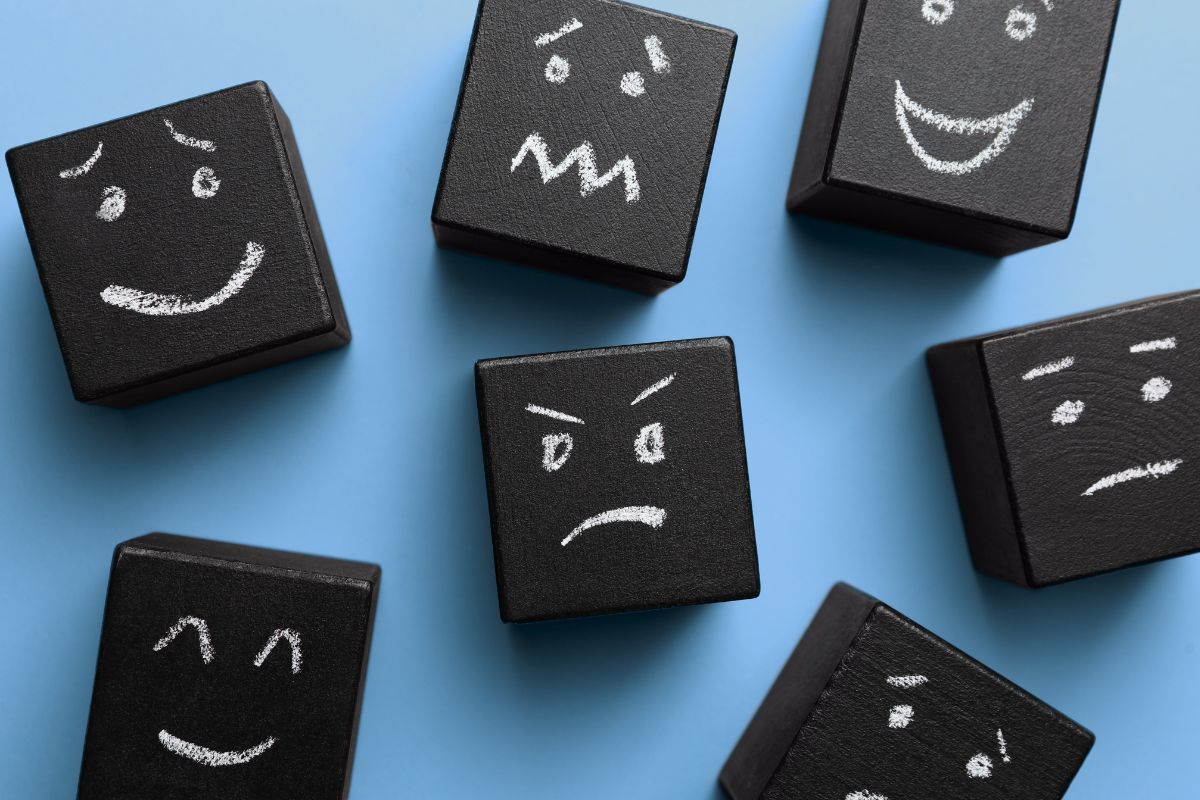Black blocks with various facial expressions depicting empathy on a blue background