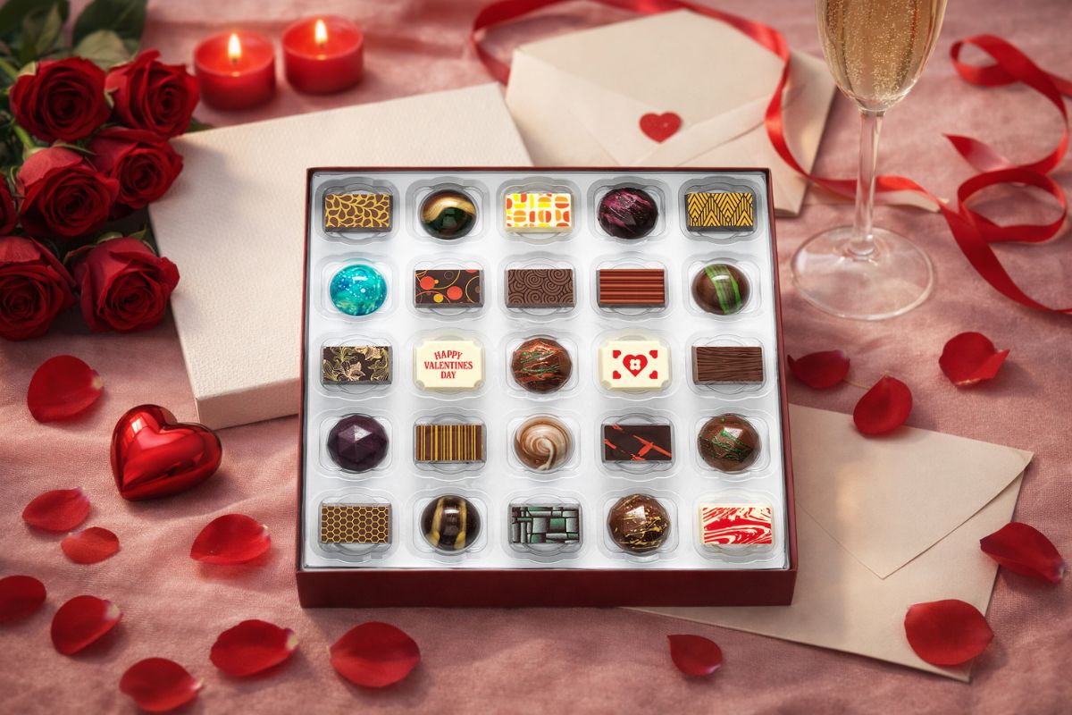 A luxury chocolate box with 25 valentine's chocolate, surrounded by roses and ribbon