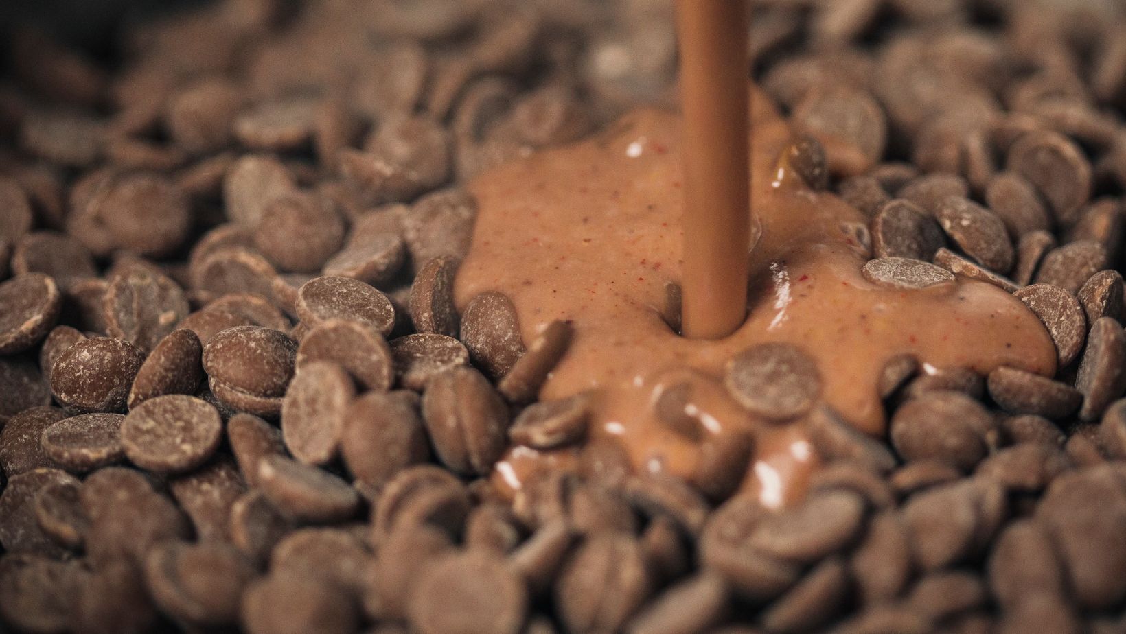 Melted milk chocolate pouring on to a pile of chocolate chips