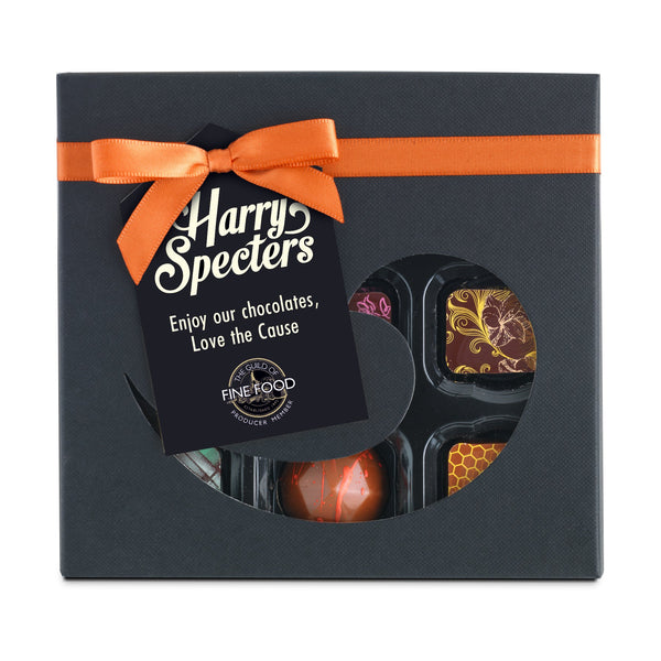 A box of 9 chocolates by Harry Specters in a cut out box with a bow for a chocolate subscription
