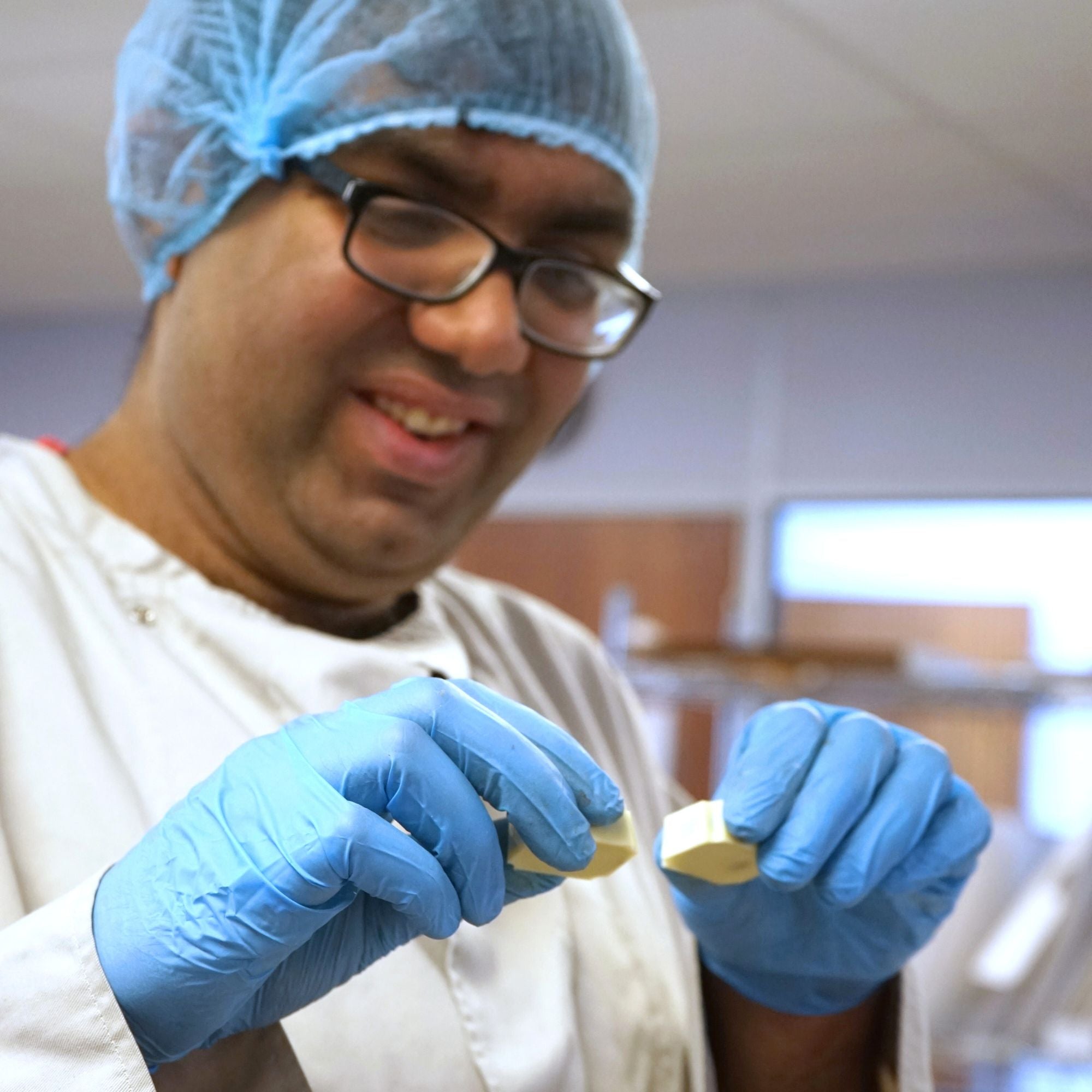 An autistic employee performing quality checks on two personalised chocolates