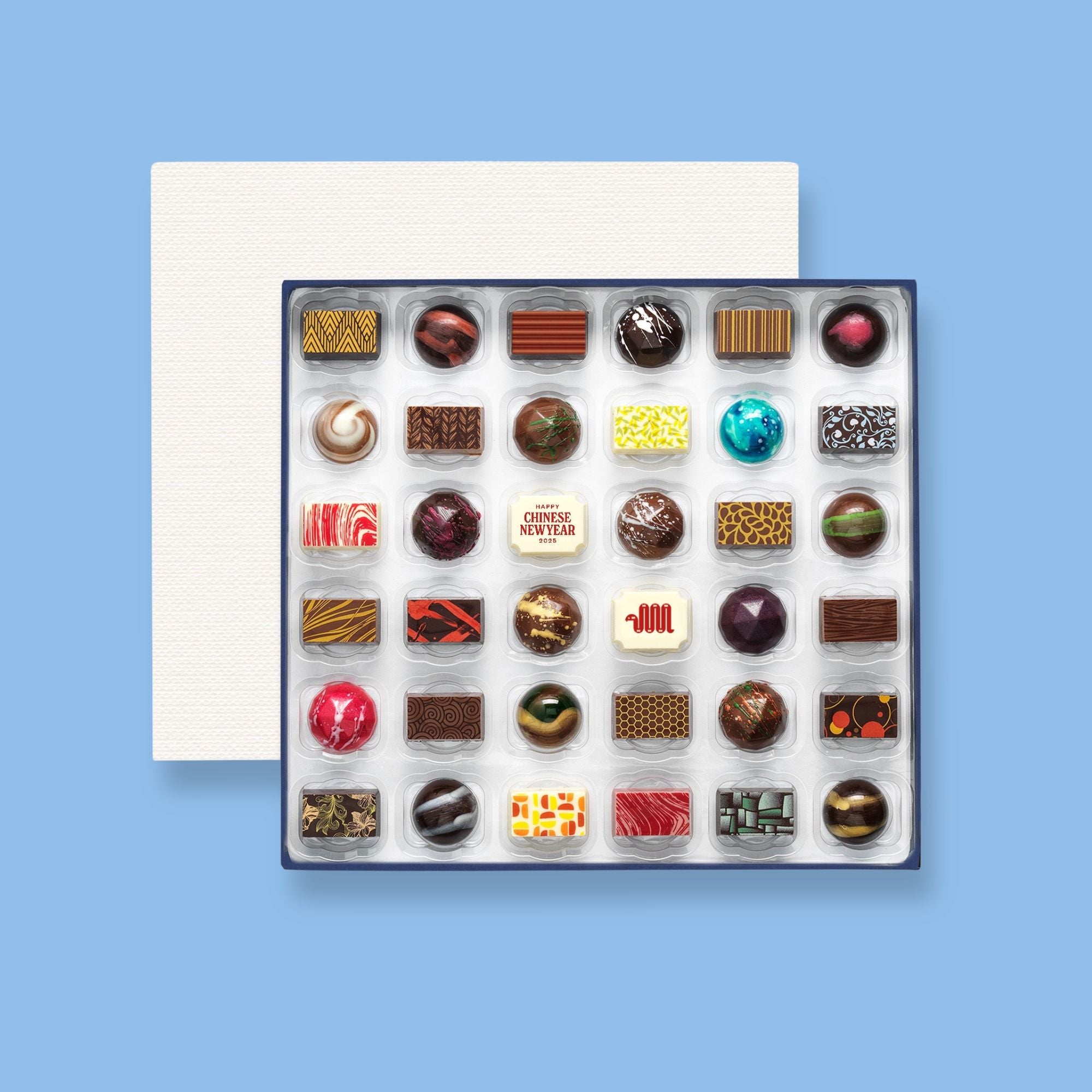 A box of 36 artisan chocolates colourfully decorated and featuring two Chinese New Year themed designs