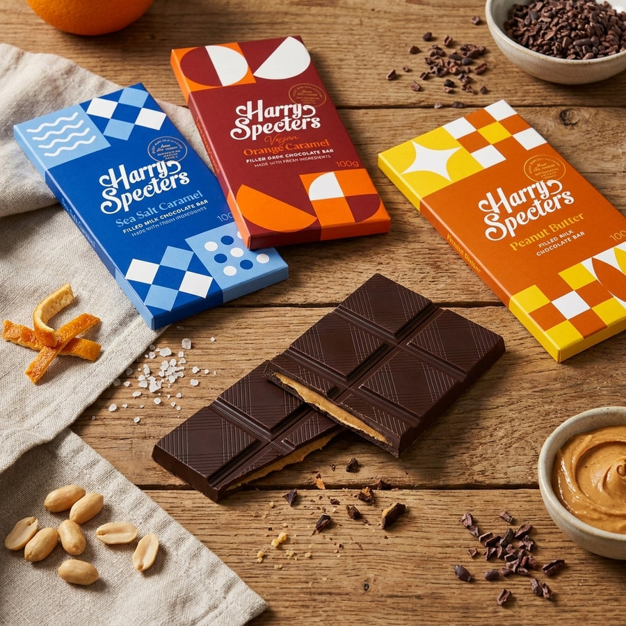Four Harry Specters chocolate boxes on a tble. Three of them are closed and the fourth one is open to reveal the chocolates inside the box