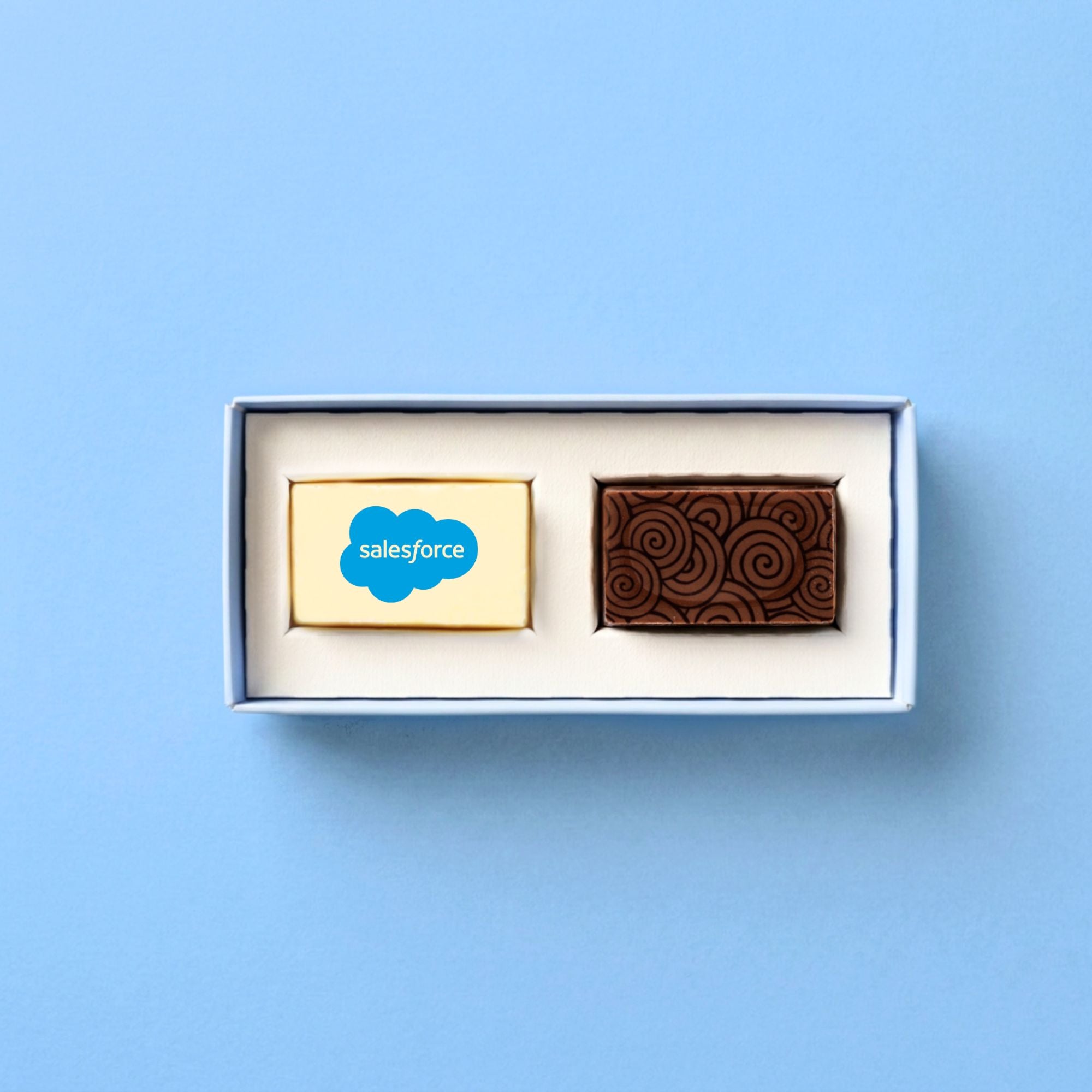 Two premium chocolates in a box with Salesforce logo on a light blue background