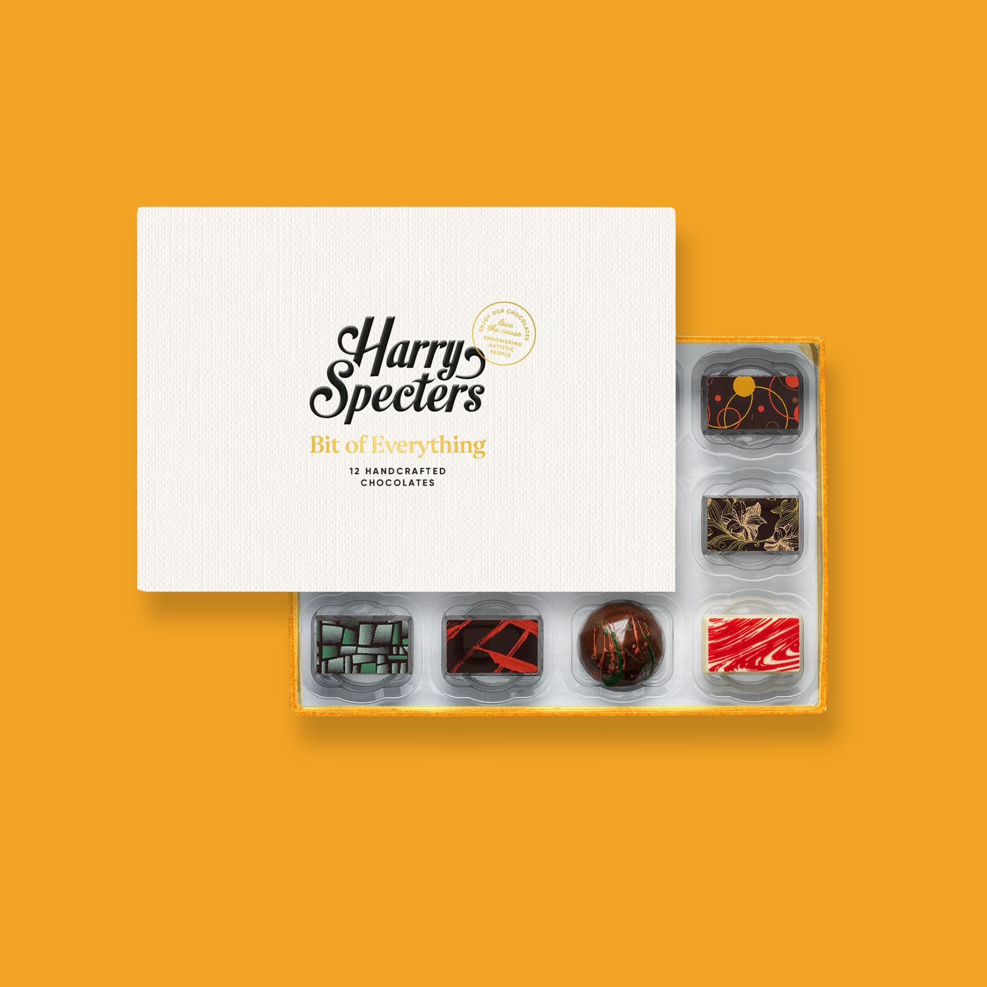 A box of 12 artisan chocolates by Harry Specters including Happy Holidays themed designs partially covered by a box lid 