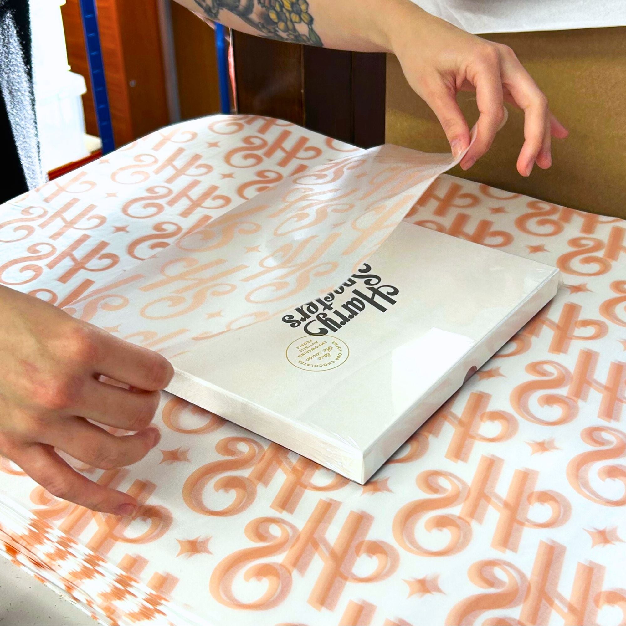 A luxury chocolate box being hand-wrapped in Harry Specters tissue paper