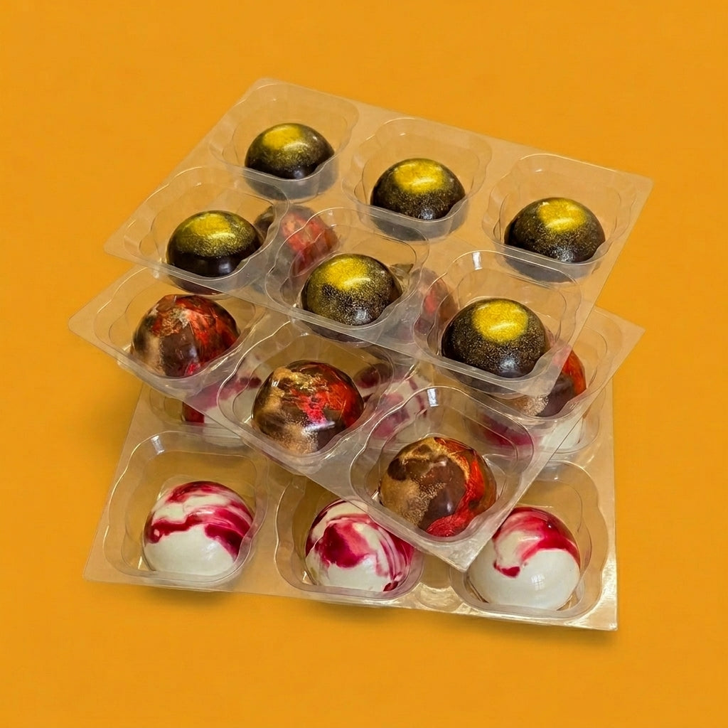 Assorted chocolate truffles in clear packaging on an orange background