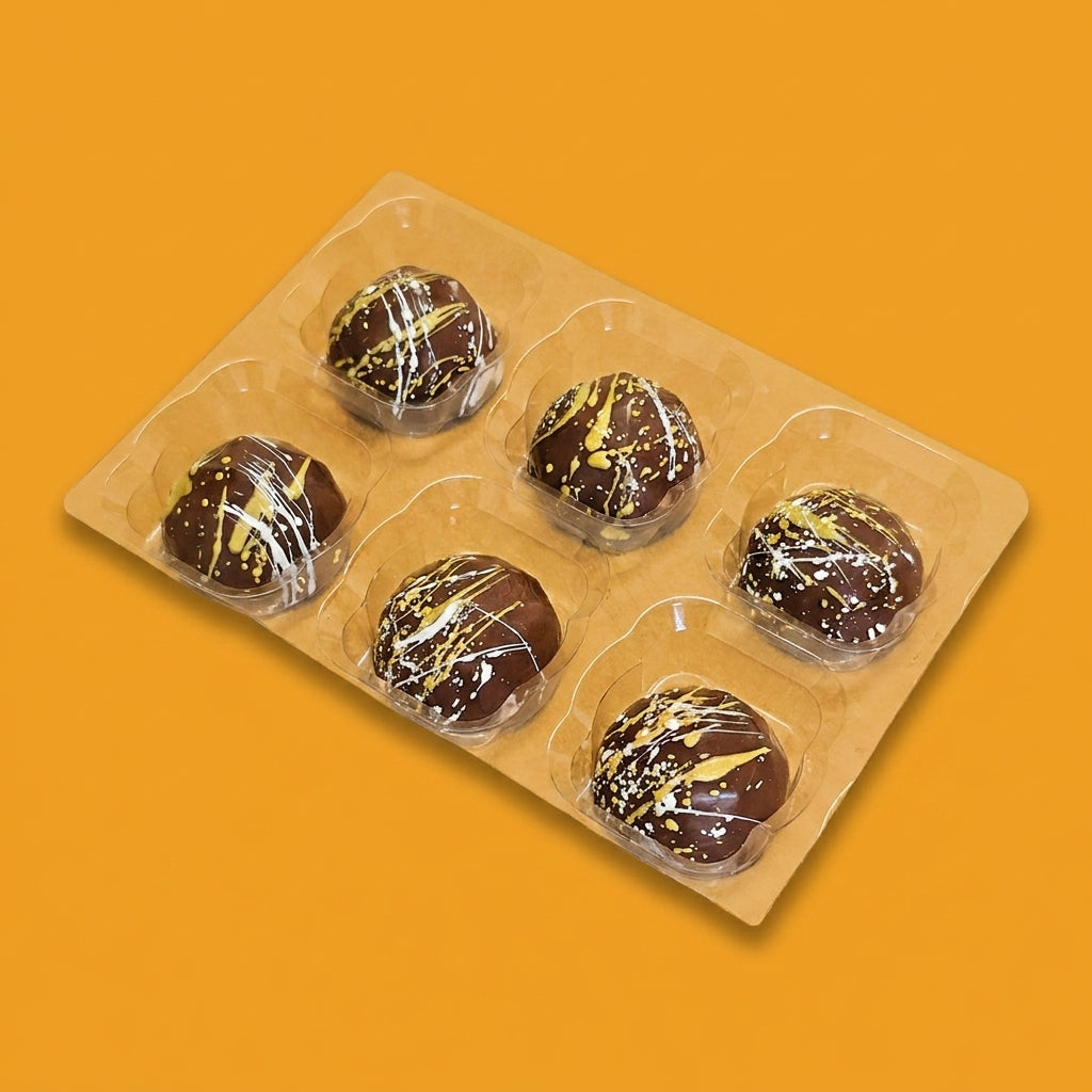 Six pina colada milk chocolates in a tray, decorated with a white and yellow pattern