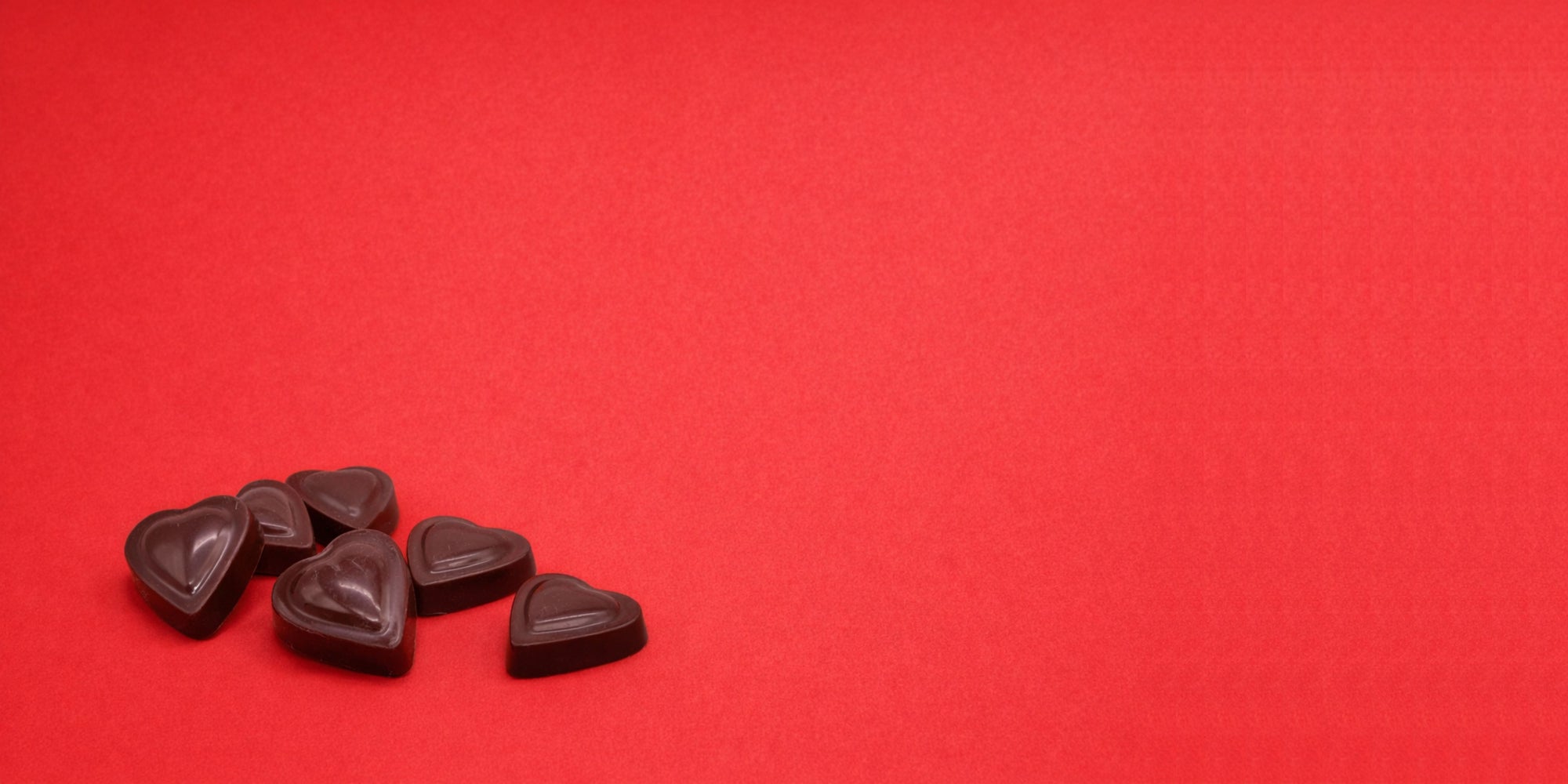 Dark chocolate valentine's day hearts on a red background