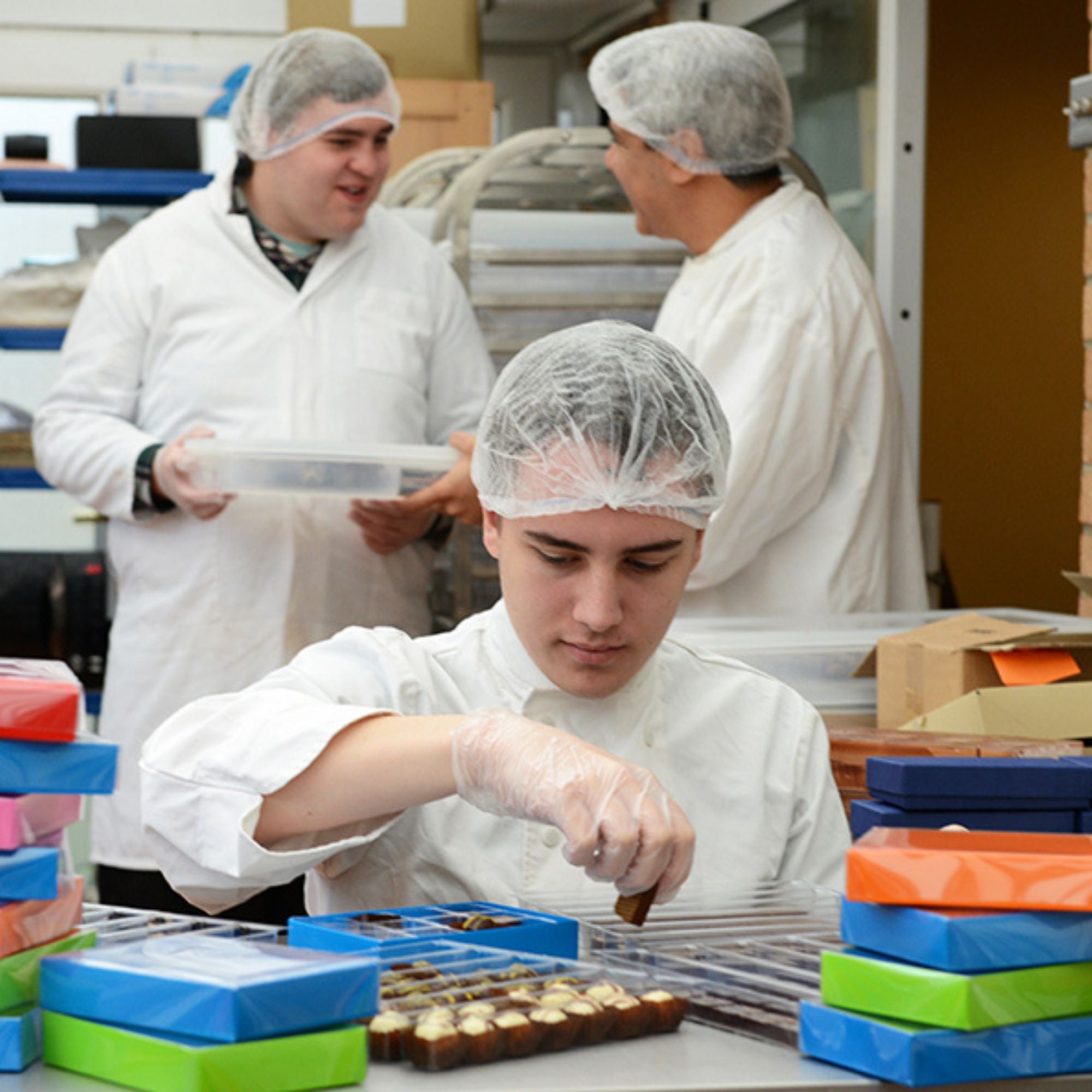 An autistic employee packing chocolate boxes in the Harry Specters factory