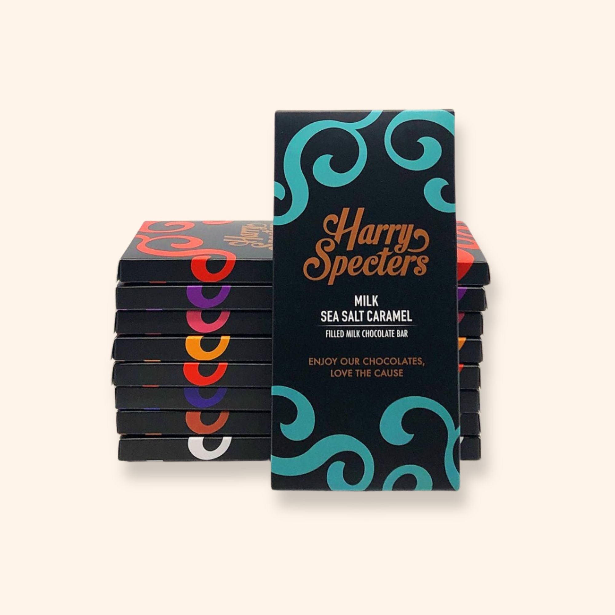 chocolate bars in colourful Harry Specters packaging. In front of the pile is a bar of sea salt caramel