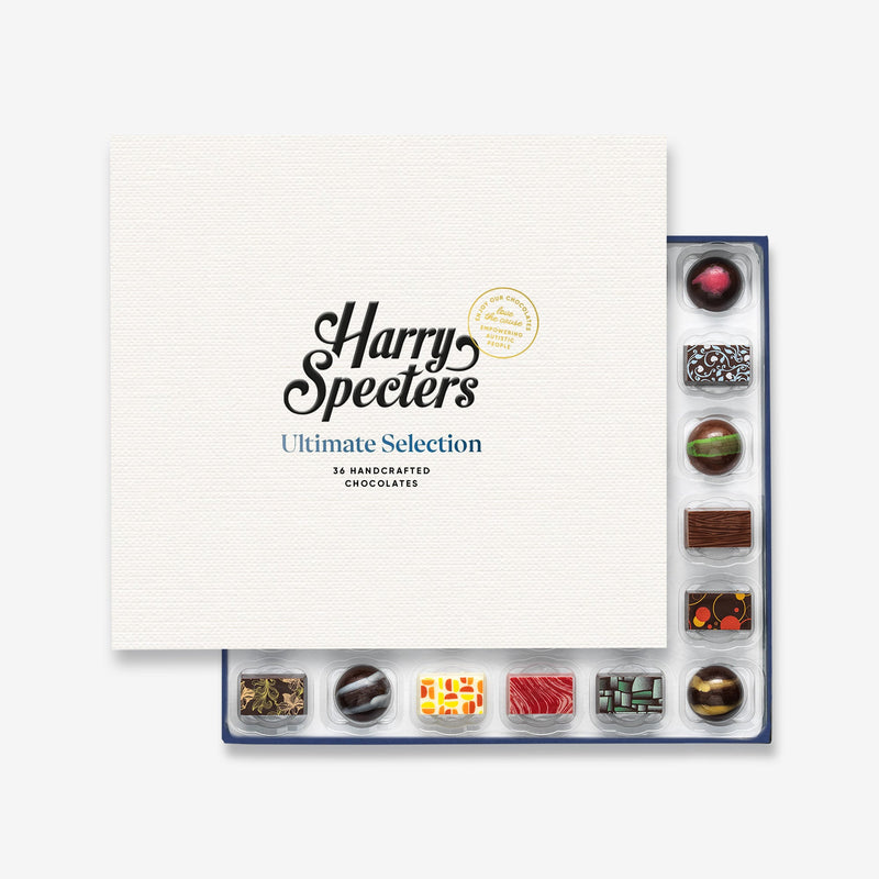 A box of 36 artisan chocolates by Harry Specters including Birthday themed designs partially covered by a box lid 