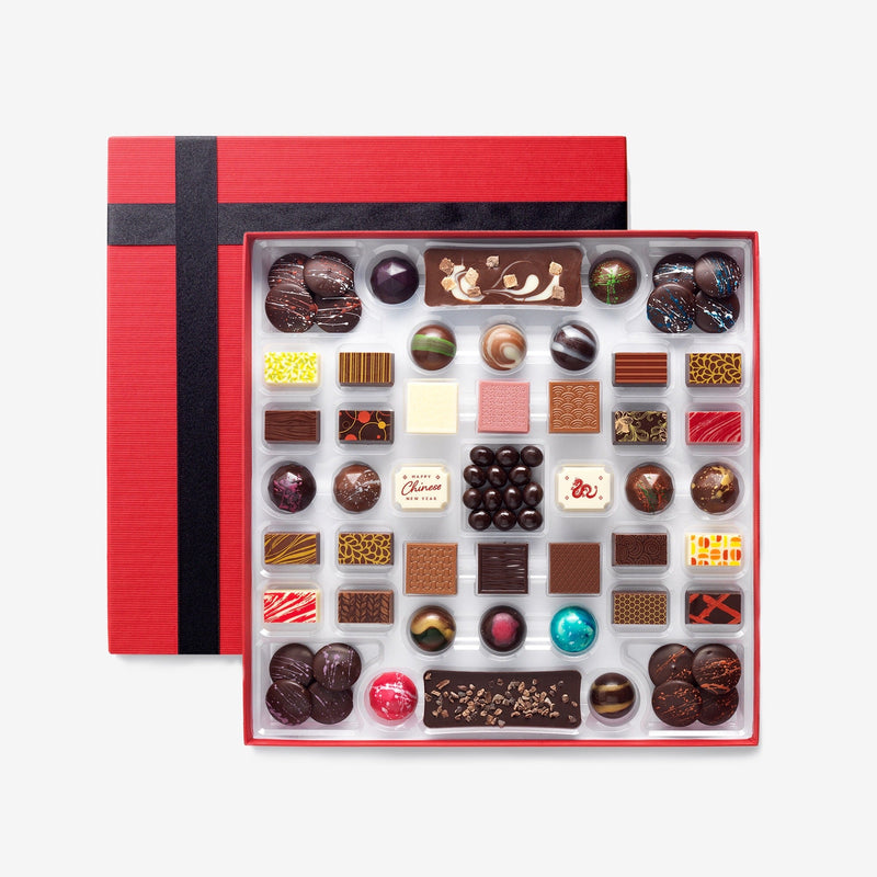 A chocolate box including buttons, bars, and coffee beans and featuring two Chinese New Year chocolates