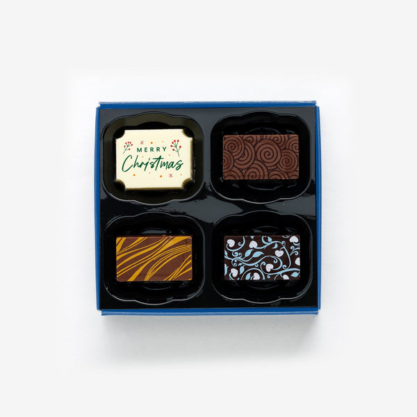 A box of 4 artisan chocolates colourfully decorated and featuring one Christmas themed design