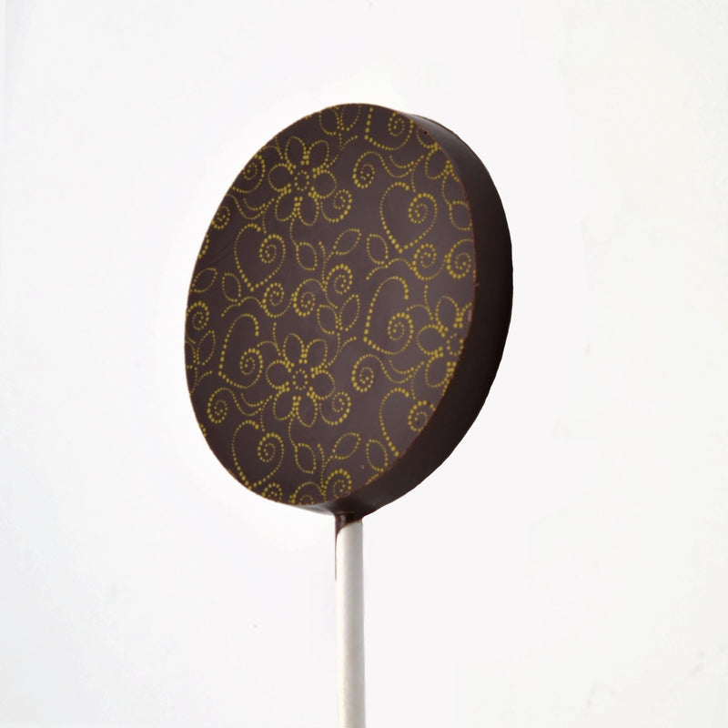 A dark chocolate lollipop featuring a hearts and flowers design
