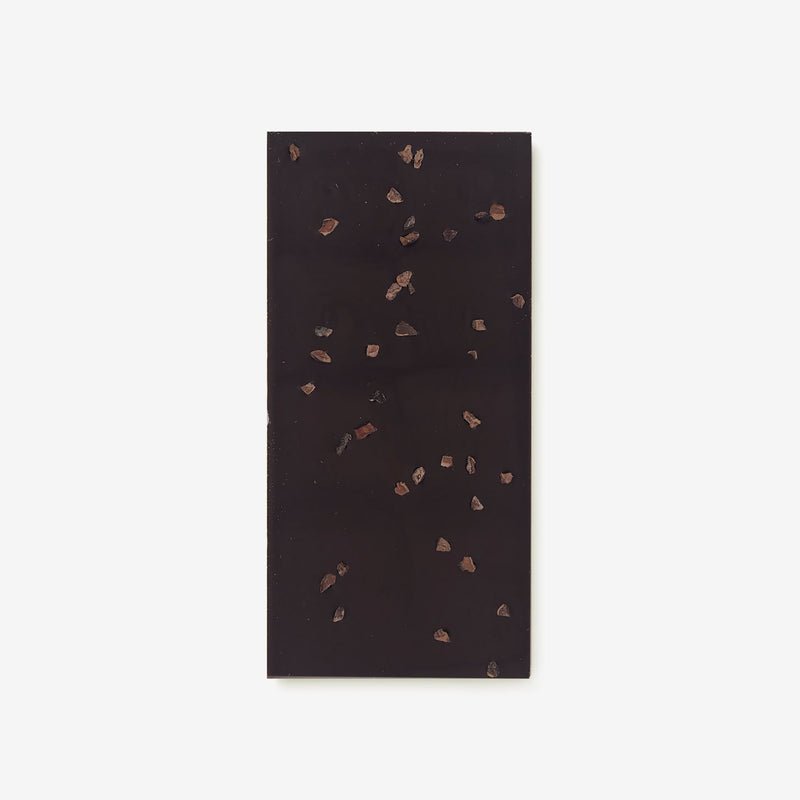 The back of a vegan dark chocolate bar by Harry Specters decorated with roasted cocoa nibs
