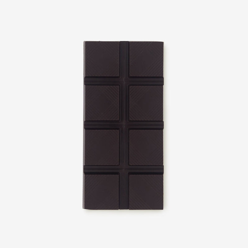 The front of a vegan dark chocolate bar by Harry Specters decorated with roasted cocoa nibs