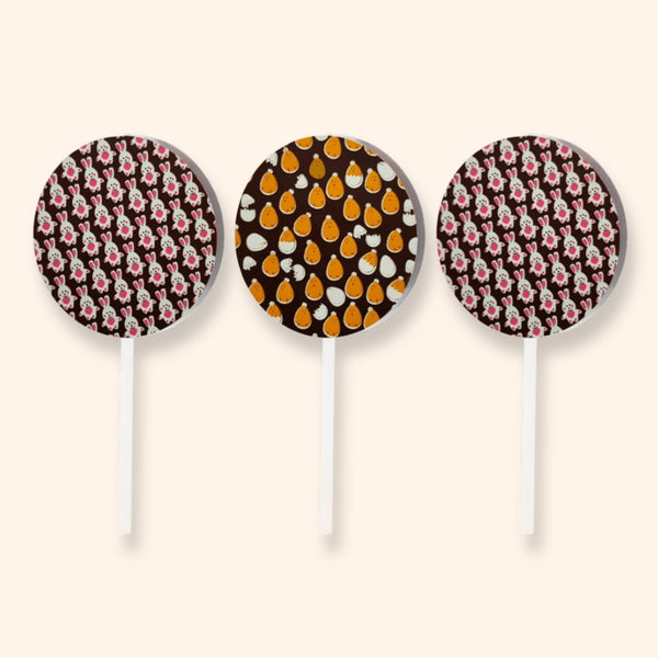 Three dark chocolate lollipops featuring designs of chicks and Easter bunnies