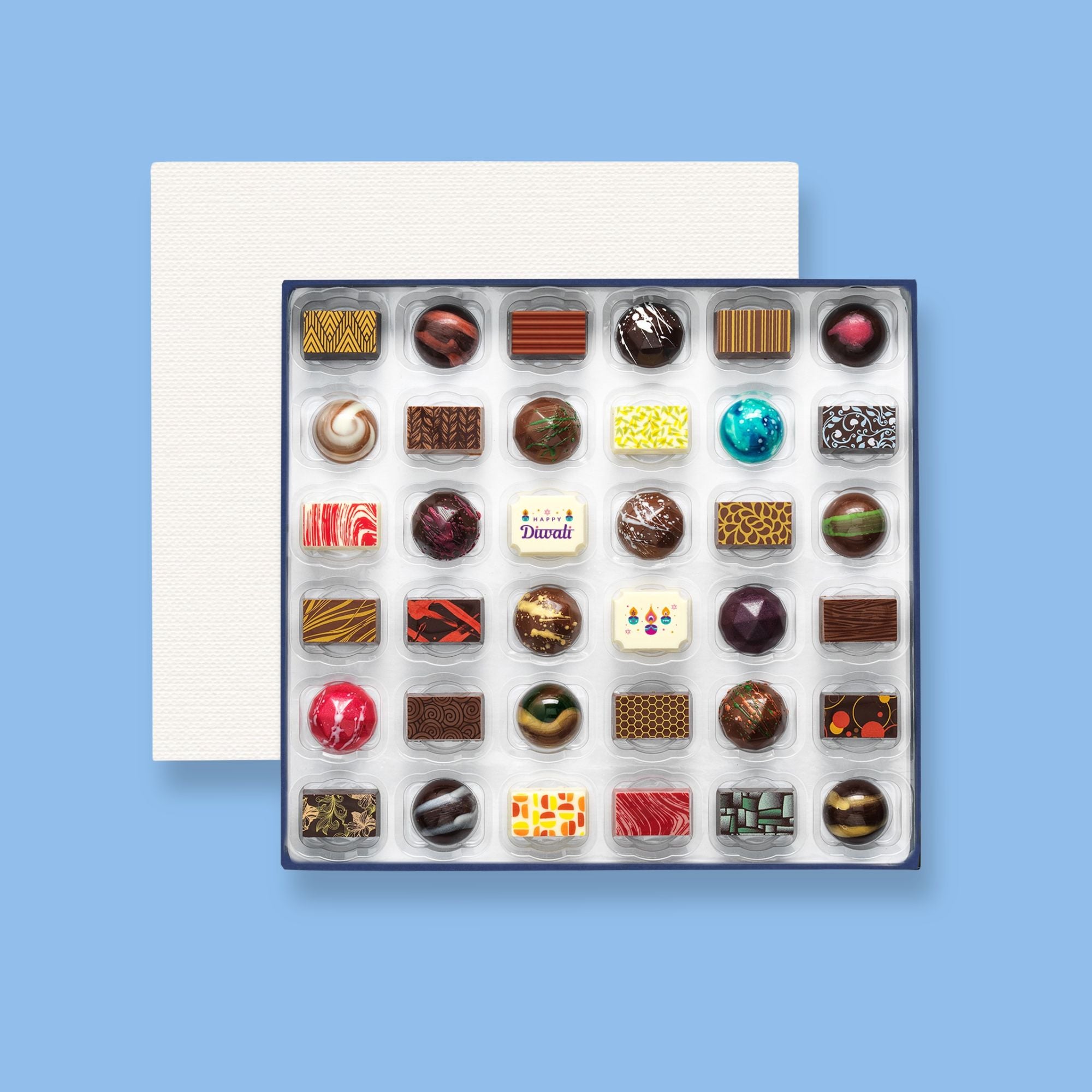 A box of 36 artisan chocolates colourfully decorated and featuring two Diwali themed designs