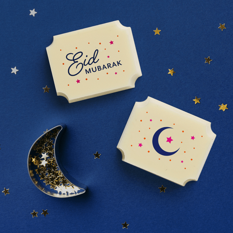 Two white chocolates with an Eid theme including one which reads Eid Mubarak