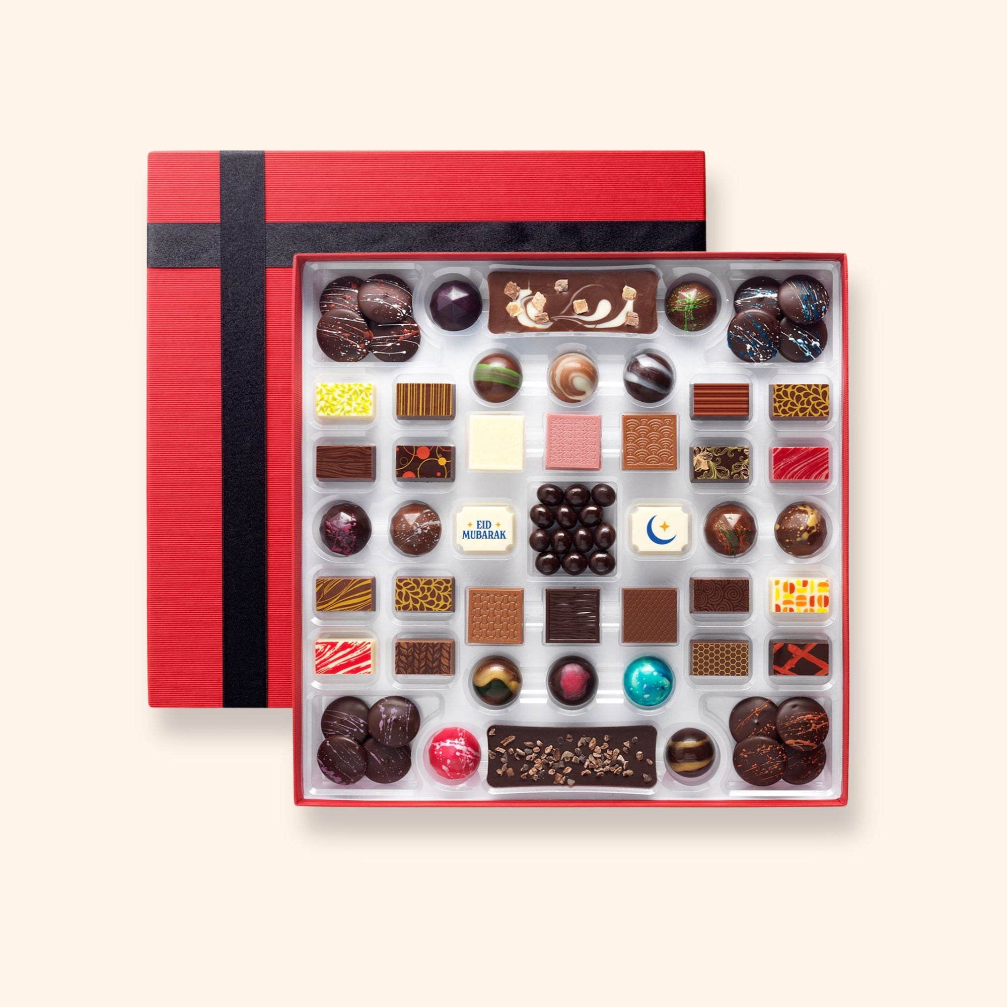 A chocolate box including buttons, bars, and coffee beans colourfully decorated and featuring two Eid Mubarak chocolates