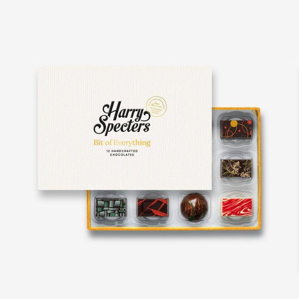 A box of 12 artisan chocolates by Harry Specters including Father's Day themed designs partially covered by a box lid 