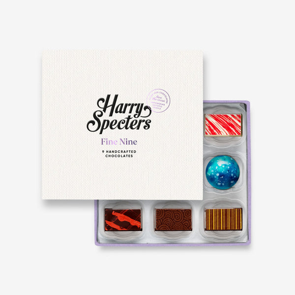 A box of 9 artisan chocolates partially covered by a box lid featuring the name Harry Specters