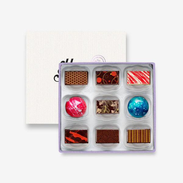 A box of 9 artisan chocolates colourfully decorated 