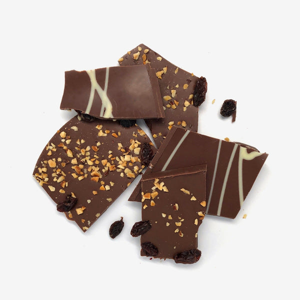 A pile of milk chocolate shards with hazelnuts and raisins