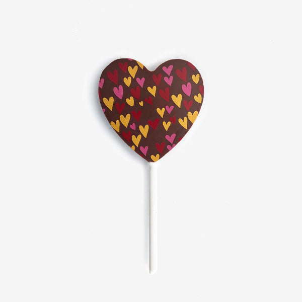 A heart shaped milk chocolate lollipop featuring a colourful heart design