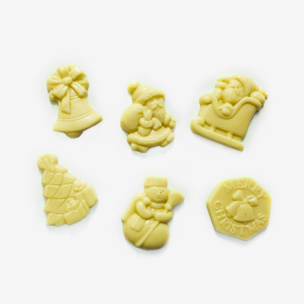 A group of white chocolate Christmas shapes including snowmen, a Christmas tree, and Santa Claus