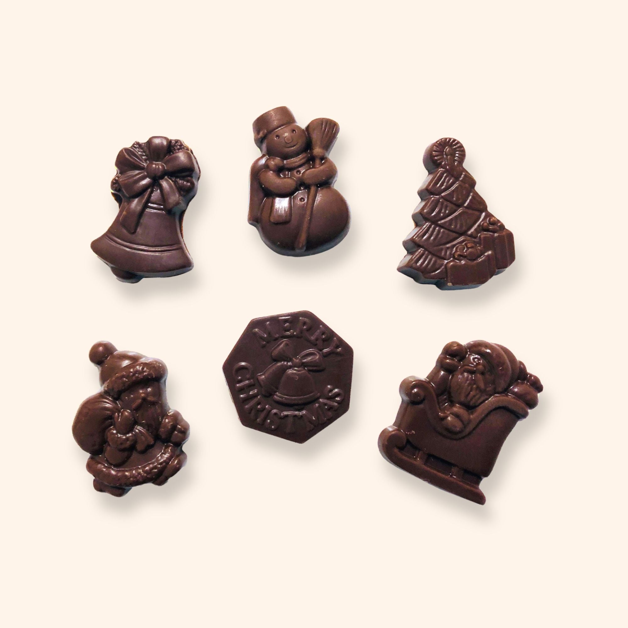 A group of milk chocolate Christmas shapes including snowmen, a Christmas tree, and Santa Claus