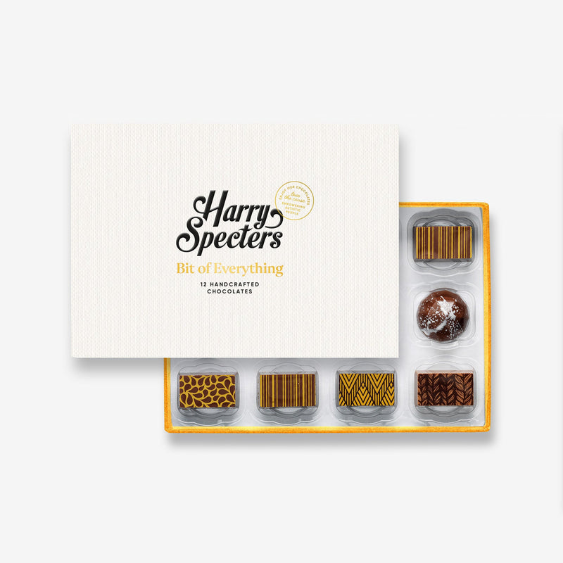 A box of 12 artisan chocolates with nuts partially covered by a box lid featuring the name Harry Specters