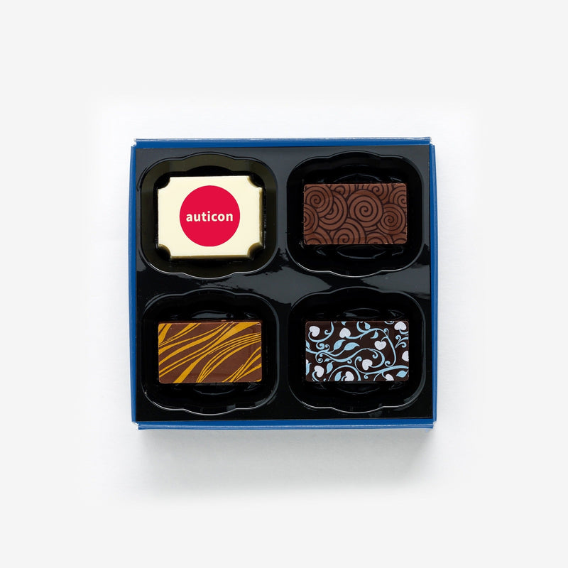 A box of 4 artisan chocolates colourfully decorated and featuring a personalised chocolate showing a company logo