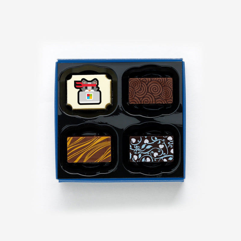 A box of 4 artisan chocolates colourfully decorated and featuring a personalised chocolate showing a company logo