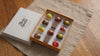 A box of artisan chocolates on a linen mat on top of a wooden table