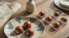 Raspberry rose chocolates in a tray and on a plate on a wooden table